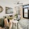 Living room with large chairs, painting on the wall, rug, and end tables with a view into the kitchen