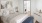 Bedroom with bed, dresser, end tables, and art on the walls