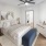 Bedroom with bed, dresser, end tables, and art on the walls